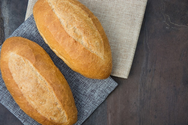 Photo french loaf on wooden background.