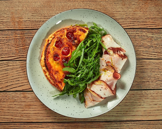 French omelette with baked ham and fresh arugula