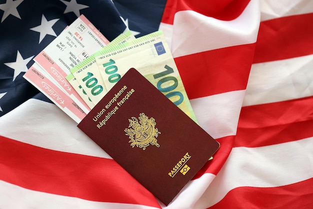 Photo french passport and euro money with airline tickets on united states national flag background close