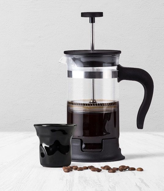 背景の側面図に分離された黒いコーヒー カップとフレンチ プレス コーヒー メーカー