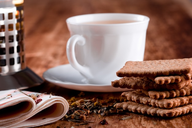 Френч-пресс, чашка свежего травяного чая и печенье крупным планом на деревянный стол