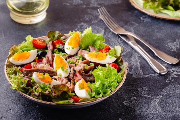 Французский салат Нисуаз с тунцом, яйцами, зеленой фасолью, помидорами, оливками, салатом и анчоусами