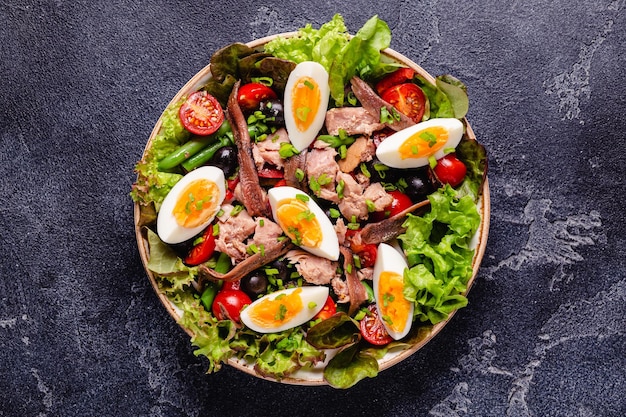 French salad Nicoise with tuna eggs green beans tomatoes olives lettuce and anchovies