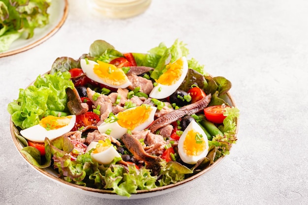 French salad Nicoise with tuna eggs green beans tomatoes olives lettuce and anchovies