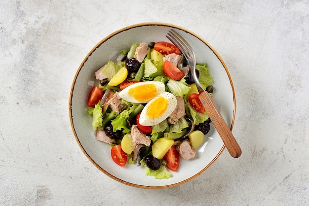 French salad with tuna, boiled potatoes, egg, green beans, tomatoes, and anchovies