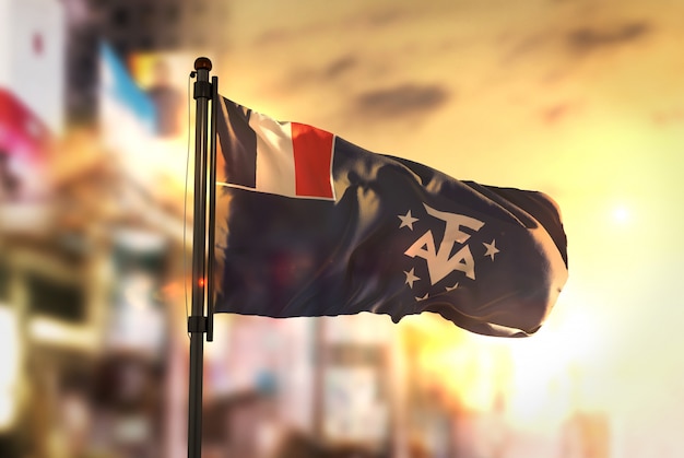 French Southern Flag Against City Blurred Background At Sunrise Backlight