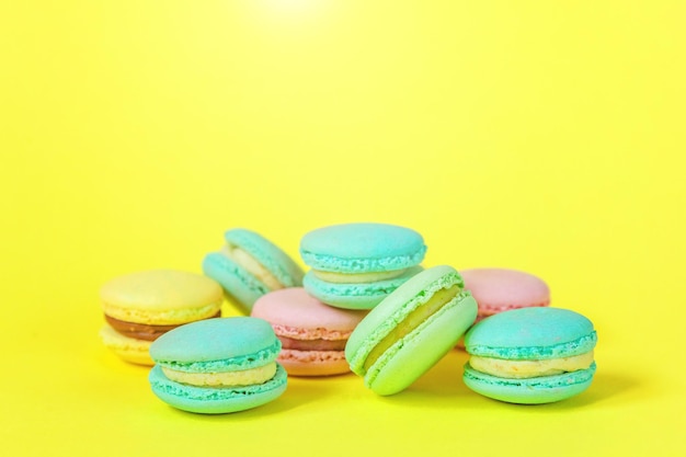 프랑스 달콤한 쿠키 최소한의 음식 베이커리 개념 노란색 배경에 분홍색 파란색 노란색 녹색 마카롱