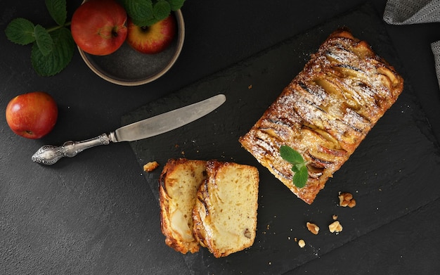 French sweet pie apple cake on dark concrete background Top view