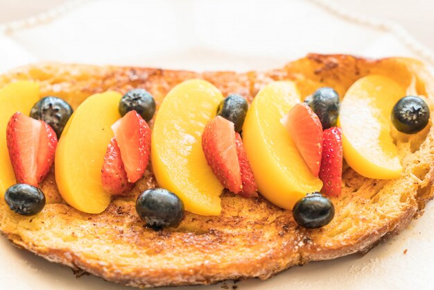 french toast with peach, strawberry and blueberries