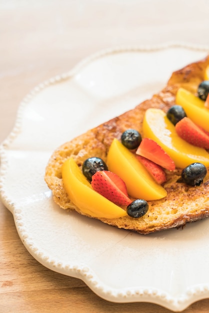 french toast with peach, strawberry and blueberries