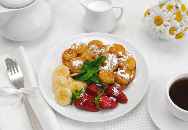 Foto french toast con sciroppo e una banana con zucchero a velo per colazione