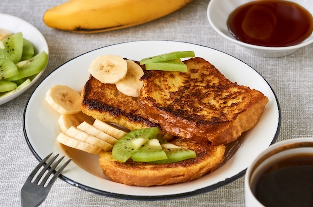 French toasts with kiwi and banana on a gray background