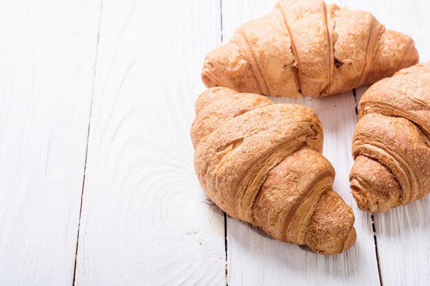 French traditional breakfast croissant on wooden background