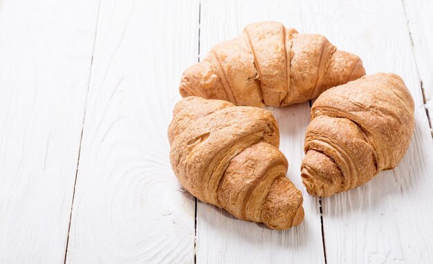 木製の背景にフランスの伝統的な朝食のクロワッサン