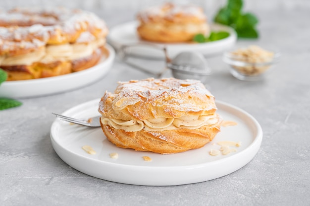 French traditional cake with praline cream, powdered sugar and almond petals on grey background