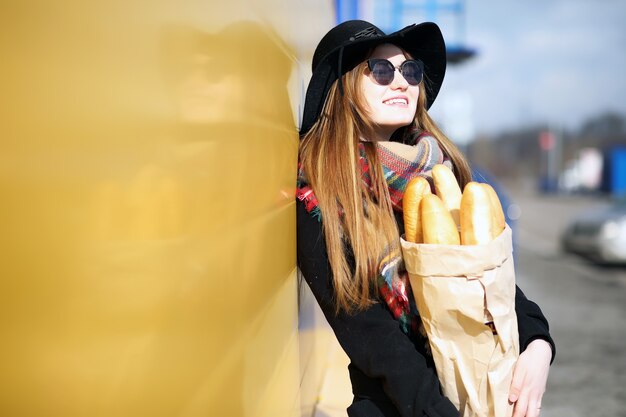 屋外の食料品店を散歩するフランス人女性