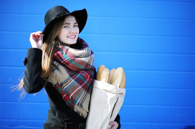 屋外の食料品店を散歩するフランス人女性