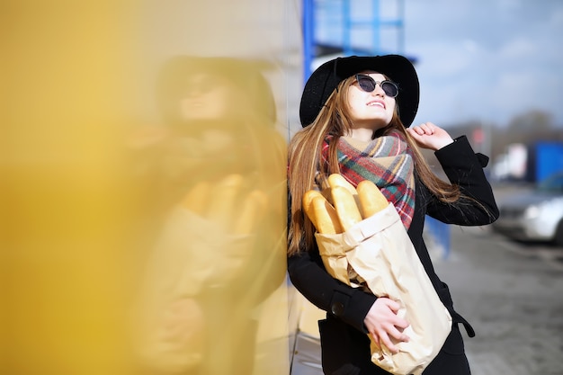 屋外の食料品店を散歩するフランス人女性