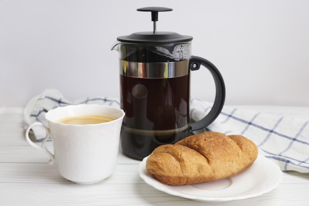 Frenchpressed ground coffee and a white porcelain cup and saucer Preparing ground coffee in a press Refreshing drink for breakfast