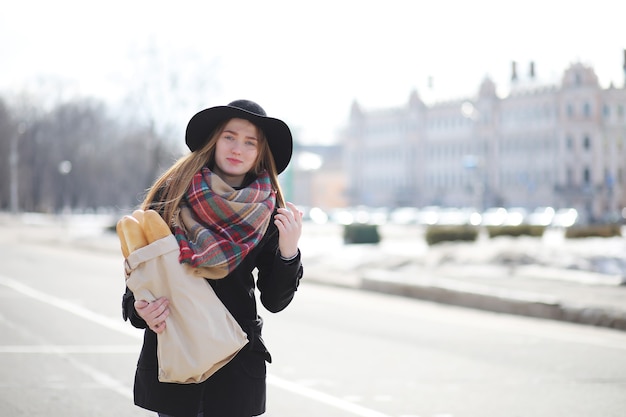 Француженка с багетами в сумке на выходе из магазина