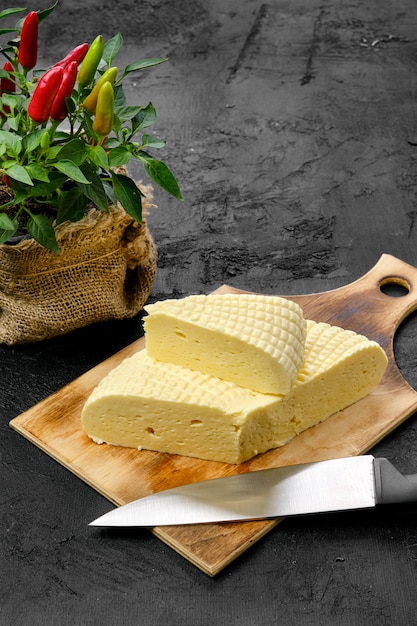 Fresh Adyghe cheese on wooden cutting board