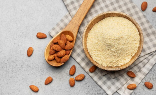 Photo fresh almond flour in a bowl and almonds
