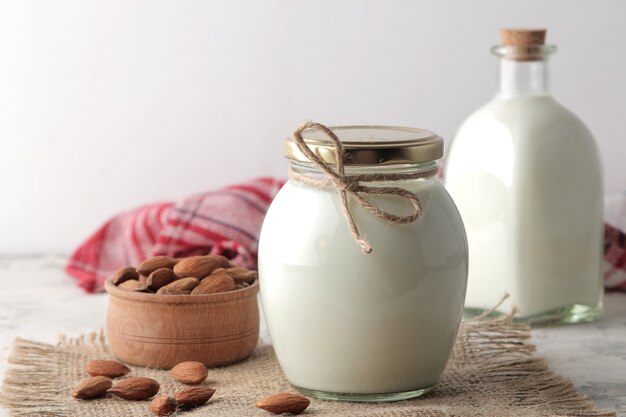 Fresh almond milk in a glass bottle and almond nuts