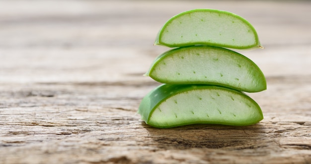 Fresh alo vera sliced for treatment and skin care on rustic wood table