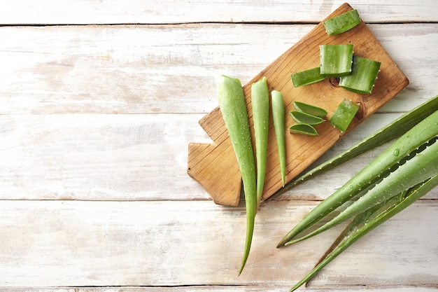 Fresh Aloe vera leaves and slices with water drops on wooden background. natural medicine concept