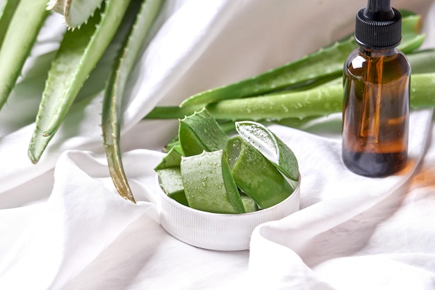 Fresh Aloe vera leaves and slices with water drops on wooden background. natural medicine concept