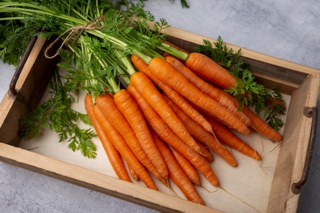 Свежая и сладкая морковь на деревянной коробке