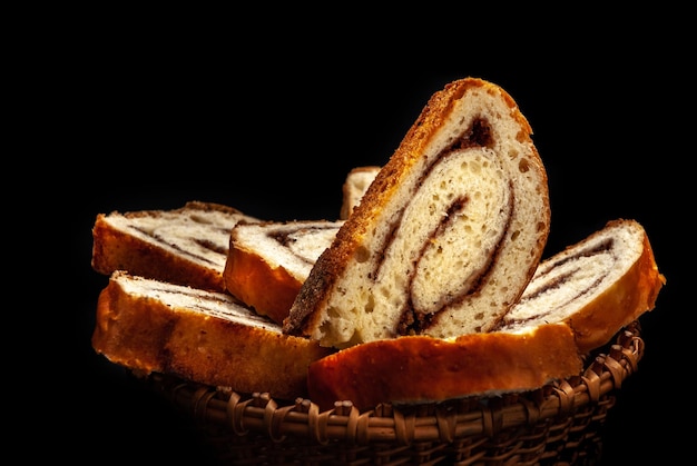 Fresh appetizing strudel with cinnamon on a black background