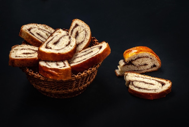 Fresh appetizing strudel with cinnamon sliced on a black background