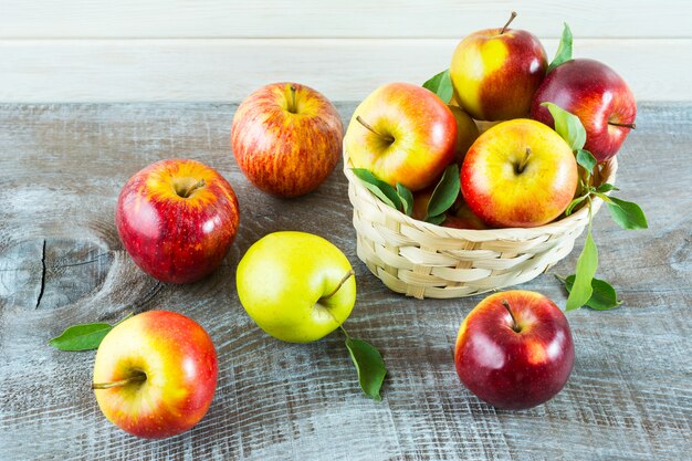 Fresh apples in the basket on the rustic background