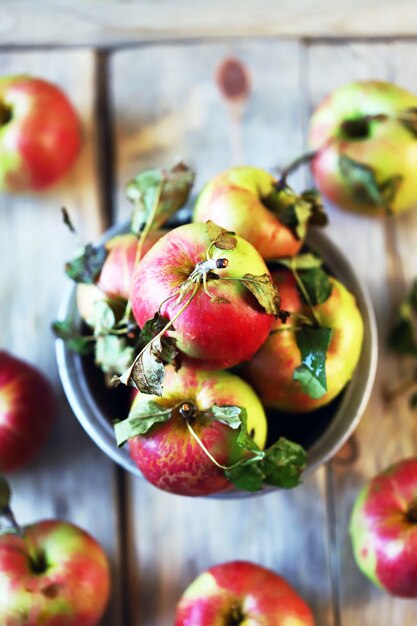 Fresh apples in a bowl on a wooden surface