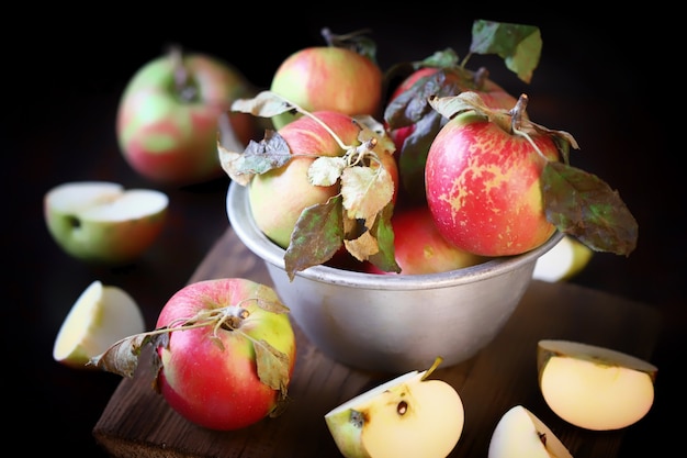 Fresh apples in a bowl on a wooden surface.