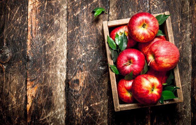 Fresh apples in the box on a wooden table