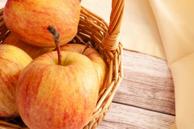 Fresh apples isolated in basket on wooden background Fresh natursl product Harvest of apples Napkin near basket with fruit Spring Food Close up