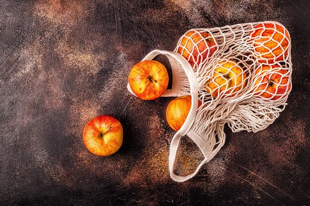 Photo fresh apples in a mesh bag on the table