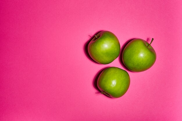 Fresh apples on pink background