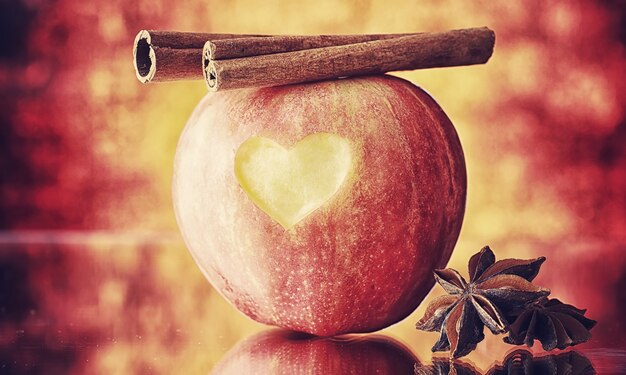 Fresh apples on a wooden board. Harvest of red apples. Fruits and cinnamon on the table.