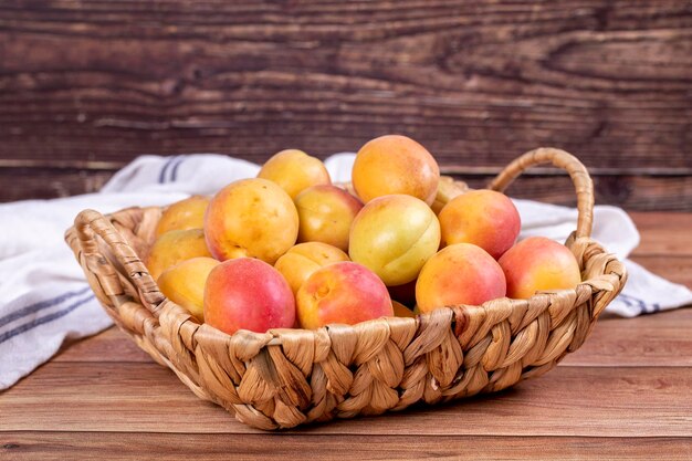 Fresh apricots Ripe apricots in basket on wood background Bulk apricots close up