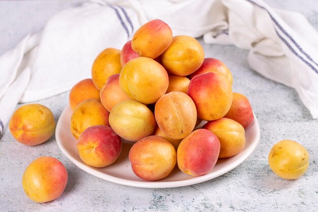 Fresh apricots Ripe apricots in a plate on a stone background Bulk apricots close up