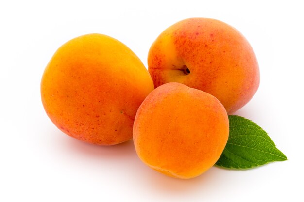 Photo fresh apricots with leaf close-up isolated on a white .