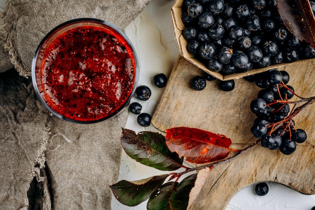 Fresh aronia berries and berry juice in a glass.