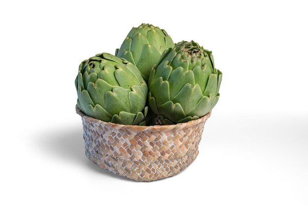 Fresh artichokes isolated from background in wicker basket