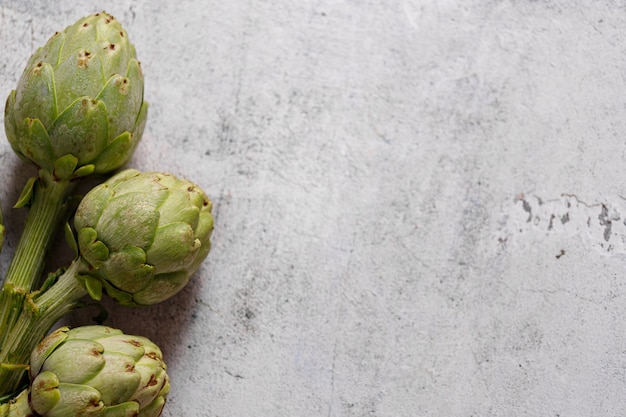 Fresh artichokes on rustic gray background