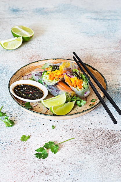 Fresh asian appetizer spring rolls nem made from rice paper and\
raw vegetables and herbs