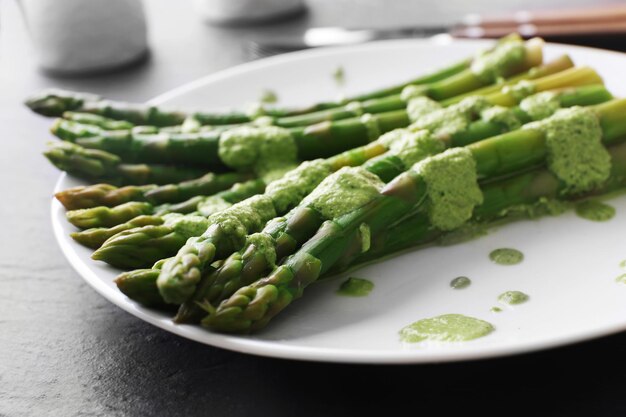 Fresh asparagus dish in green sauce on the table close up