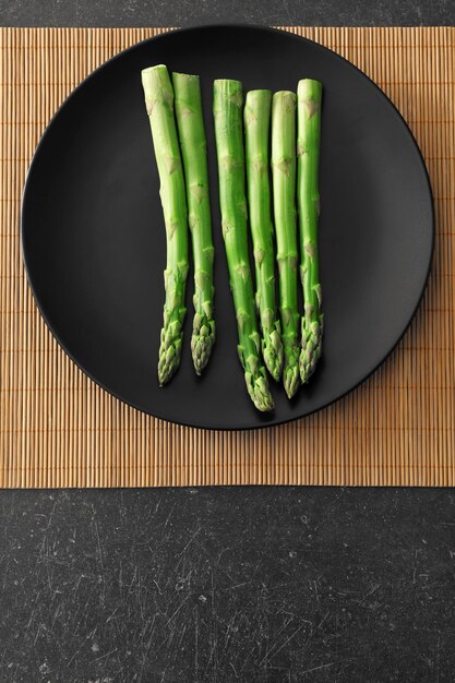 Fresh asparagus on plate top view